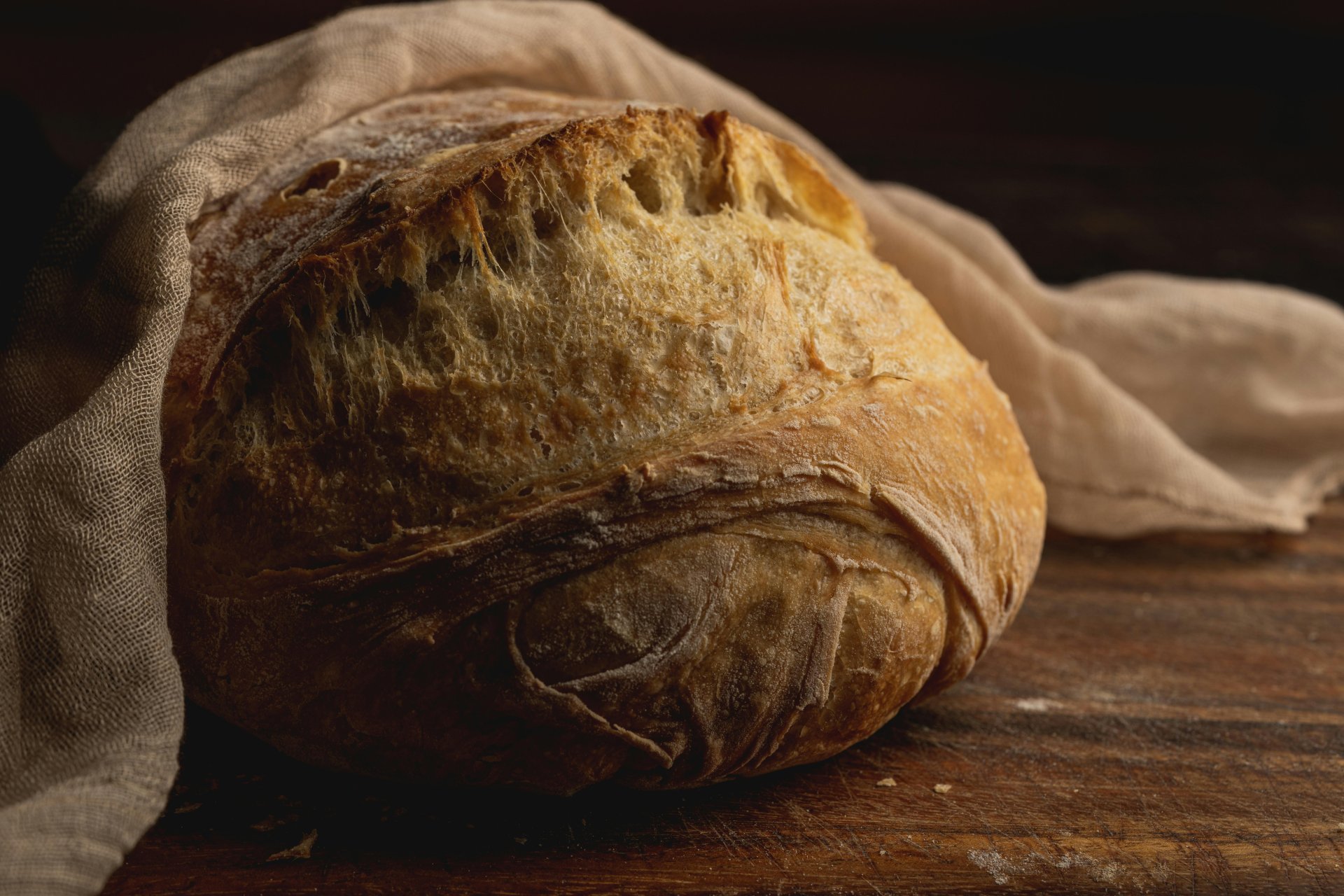 Rustic sourdough bread boule wrapped in linen cloth